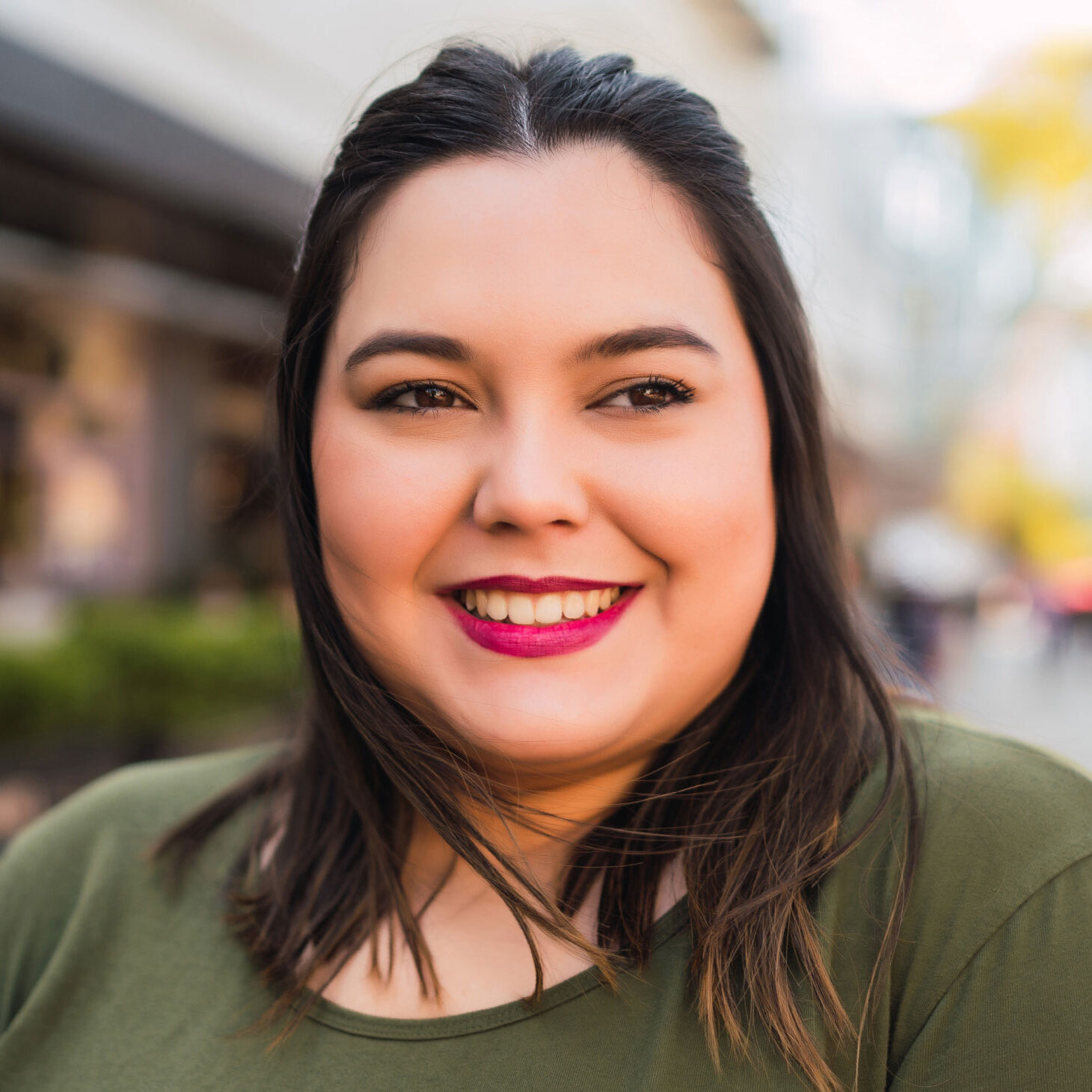 young woman in the city looking to the right and smiling